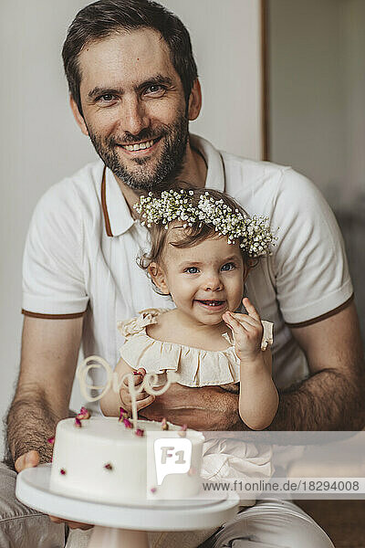 Happy father and daughter with birthday cake at home