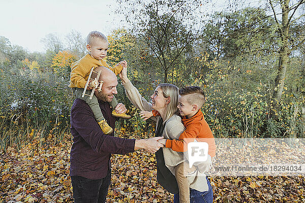 Glückliche Eltern mit Kindern  die den Herbstwald genießen