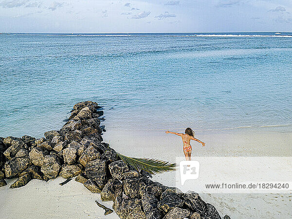 Woman with arms outstretched enjoying vacation beach  Maldives