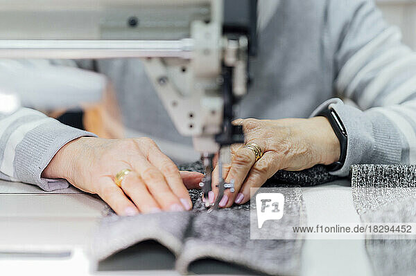 Ältere Handwerkerin benutzt Nähmaschine in der Werkstatt