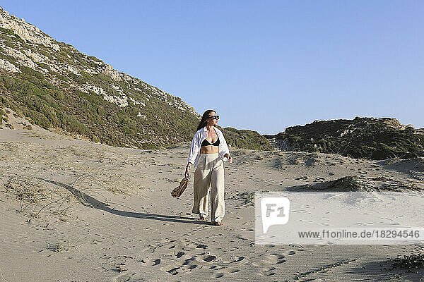 Junge Frau spaziert an einem sonnigen Tag am Strand  Patara  Türkei