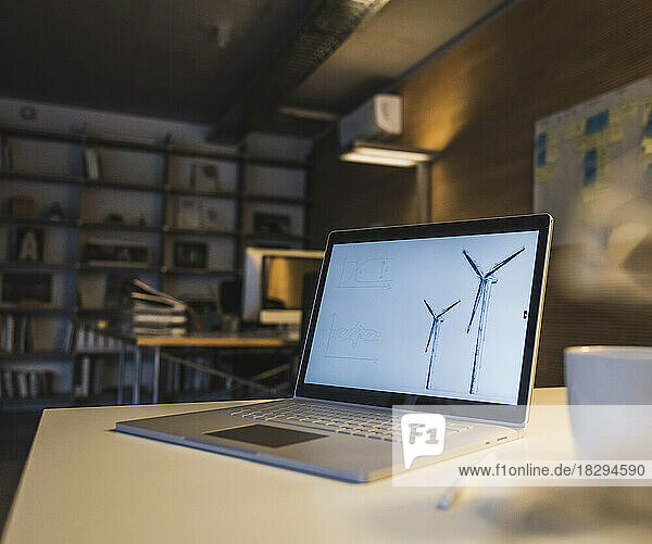 Laptop with design of wind turbine kept on desk