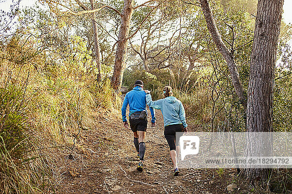 Paar geht gemeinsam auf unbefestigter Straße im Wald spazieren
