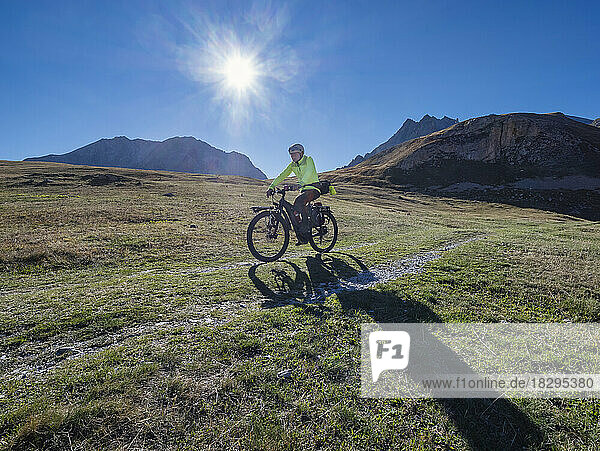 Älterer Mann fährt Mountainbike an einem sonnigen Tag unter blauem Himmel  Nationalpark Vanoise  Frankreich