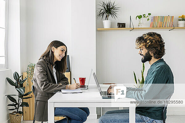 Happy business colleagues working at desk in office