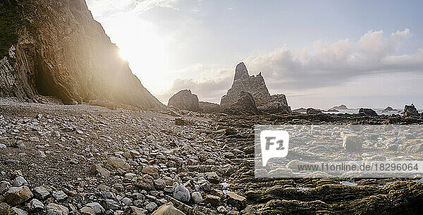 Rocky coastline in front of sky at sunset