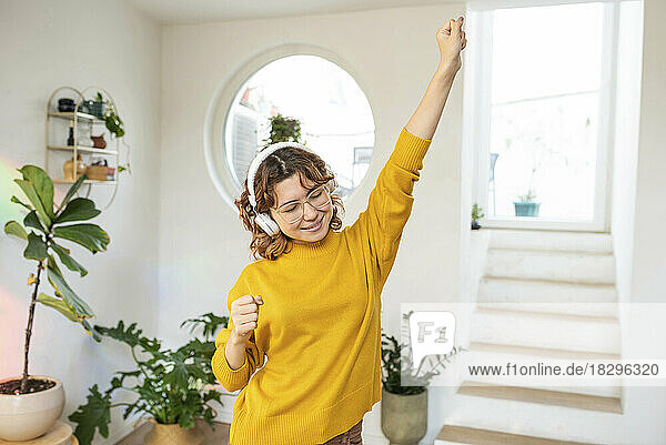 Lächelnde junge Frau  die Spaß beim Tanzen zu Hause hat