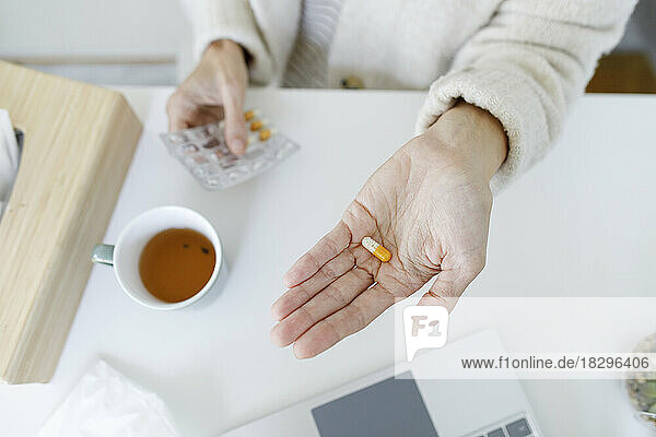 Hand of woman holding capsule pill