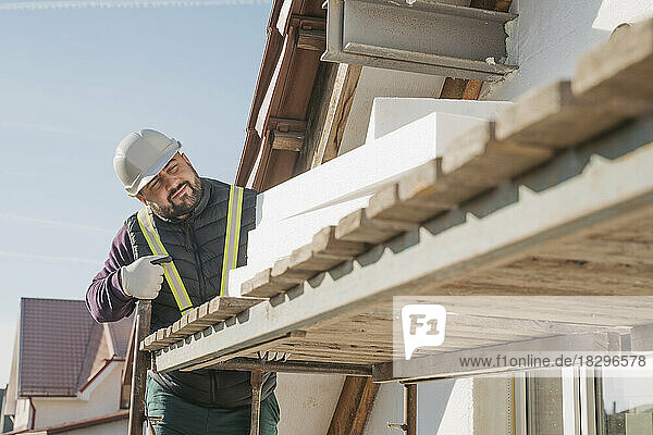 Construction worker with polystyrene foam working at site