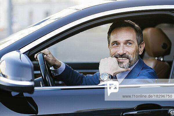 Thoughtful mature businessman sitting at driver's seat in car