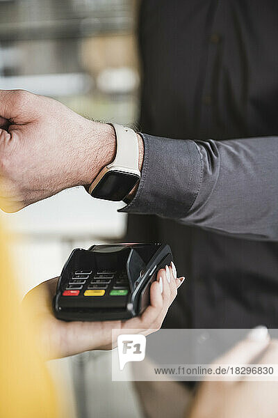 Geschäftsmann zahlt mit Smartwatch am Kartenlesegerät