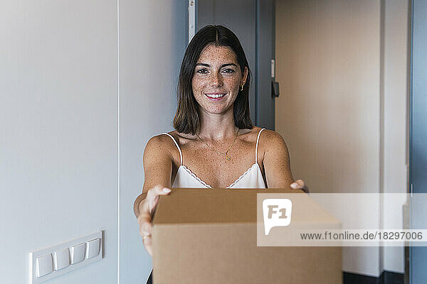 Happy woman holding box container at home