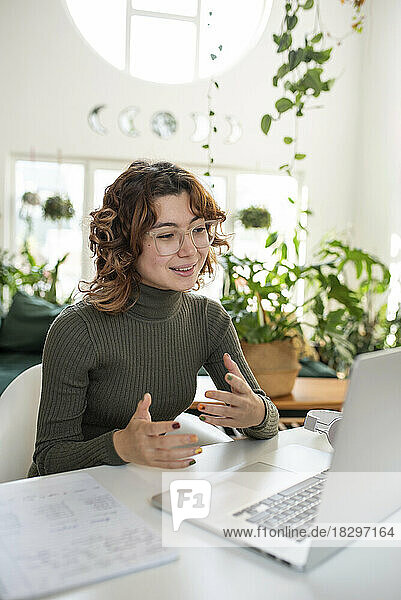 Freelancer gesturing through video call using laptop at home