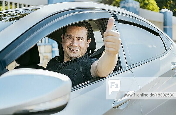 Man in his car giving thumbs up  Happy Driver giving a thumbs up. Satisfied driver man showing thumb up. Concept of satisfied car owner