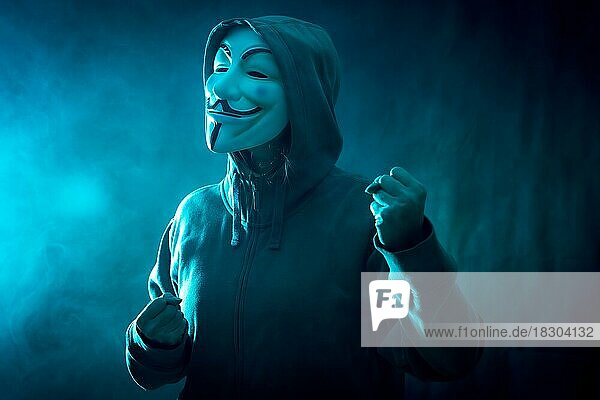 Hacker mit anonymen Maske mit einer Herstellung Kampf Symbol  mit einem Hintergrund von Rauch