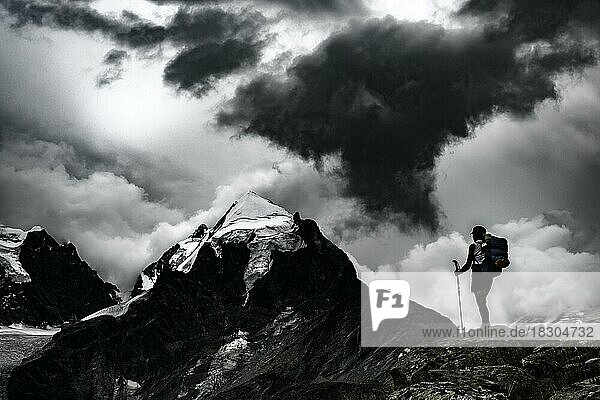 Climbers in front of summit of Bernina Group with dramatic clouds  St Moritz  Engadin  Graubünden  Switzerland  Europe