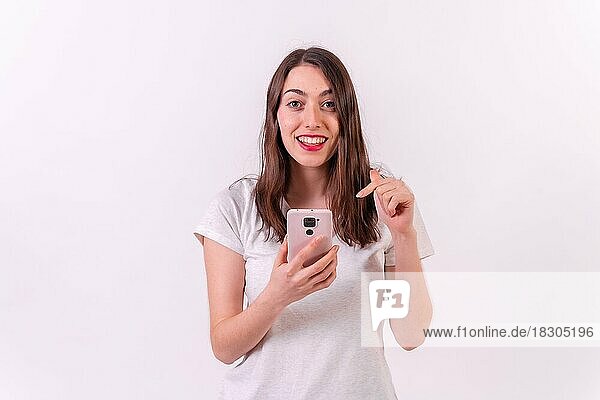 Kaukasische Frau mit einem Handy in der Hand vor weißem Hintergrund  Technologiekonzept