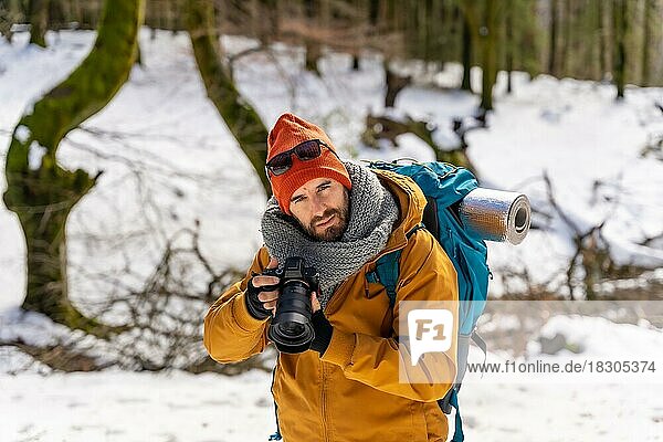 Portrait of photographer enjoying taking photos in winter on the mountain with snow  winter hobby