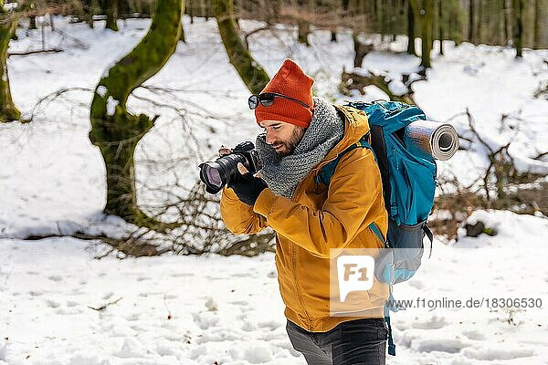 Photographer enjoying taking photos in winter on the mountain with snow  winter hobbies