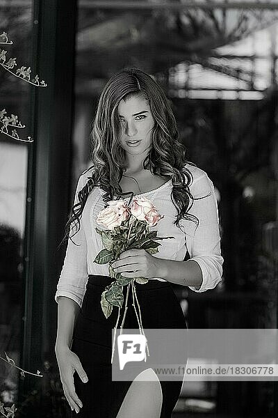 Frau in schwarz-weiß mit farbigen Rosen in der Hand