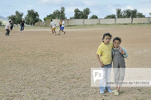 Girls as spectators  men playing football  settlement of the poorer population outside Fes  Morocco  Africa
