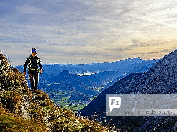 Mountaineer walking on a narrow path above the Salzach valley  in the background Osterhorn group and Hoher Dachstein  Golling  Salzburger Land  Austria  Europe