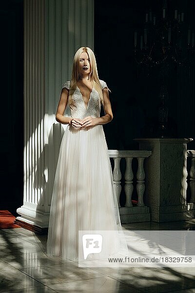 Full length portrait of a beautiful fashion bride in contrast sunlight. Wedding make up and hair