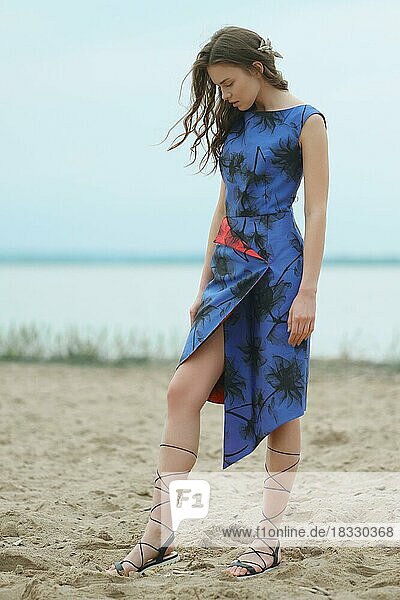 Lifestyle-Porträt einer jungen Frau  die auf dem Sand spazieren geht