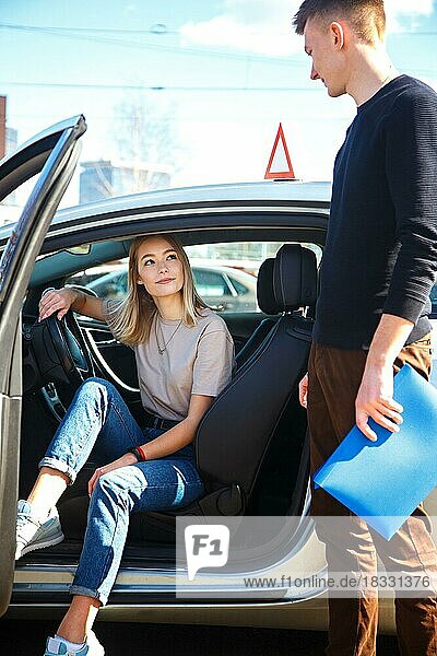Der Fahrer ist ein Fahrschullehrer und eine Studentin in einem Prüfungswagen. Lektion auf der Rennstrecke