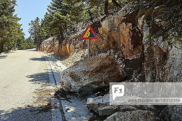 Dreieckiges Verkehrsschild Achtung Steinschlag riesiger Felsbrocken am Straßenrand  Berg Enos  Insel Kefalonia  Ionische Inseln  Griechenland  Europa