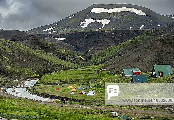Zelte und Hütten zwischen Vulkanlandschaft mit schwarzem Sand und grünem Gras  Ásgarður  Kerlingarfjöll  isländisches Hochland  Island  Europa
