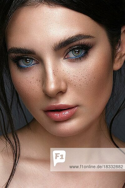 Schönes Mädchen mit hellen modischen Make-up  Sommersprossen und blauen Augen. Schönes Gesicht. Foto im Studio aufgenommen