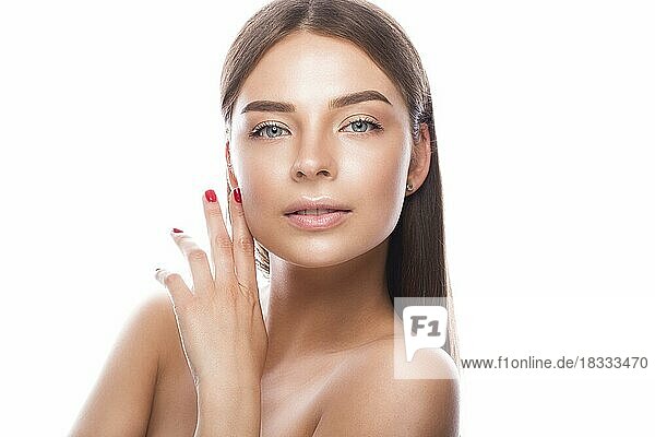 Beautiful young girl with a light natural make-up and perfect skin. Beauty face. Picture taken in the studio on a white background