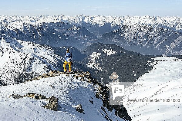 View of the Inn Valley  mountaineer at the summit of the Pirchkogel  mountains in winter  Sellraintal  Kühtai  Tyrol  Austria  Europe