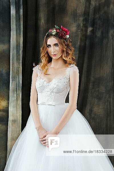 Porträt einer hübschen Braut im Hochzeitskleid mit Blumenkranz