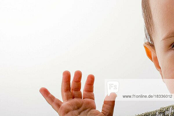 Baby holding his hand up on white background