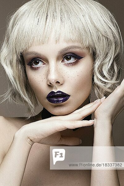 Beautiful woman with art makeup and a fashionable hair. The beauty of the face. Portrait shot in studio