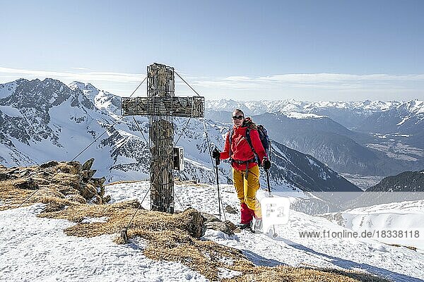Skitourengeherin am Gipfel des Mitterzeigerkogel mit Gipfelkreuz im Winter  Sellraintal  Kühtai  Tirol  Österreich  Europa