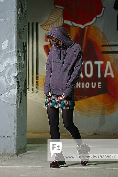 Tricky girl posing in violet fleece sweatshot with hood. Hide face