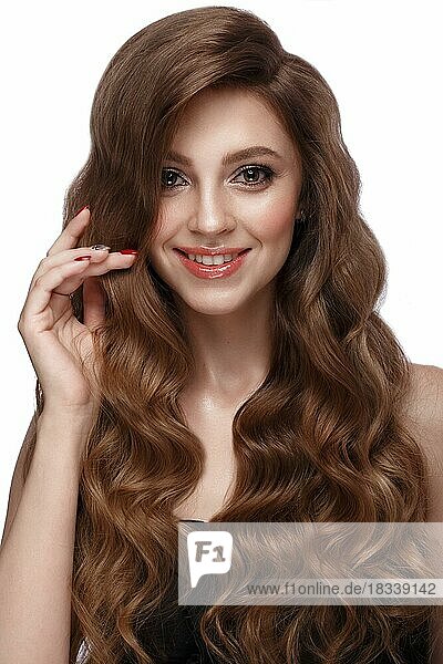 Schönes braunhaariges Mädchen mit perfekt gelocktem Haar und klassischem Make-up. Schönheit Gesicht und Haar. Bild im Studio aufgenommen