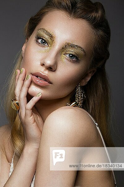 Schönes Mädchen in Unterwäsche mit kreativen Gold Make-up und Haar. Die Schönheit des Gesichts. Fotos im Studio geschossen