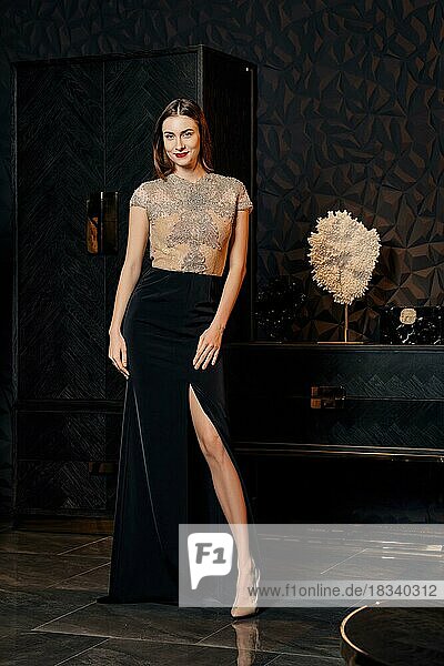 Unauffälliges Foto eines Modemodells  das in einem Kleid mit Spitzenoberteil und tiefem Ausschnitt posiert