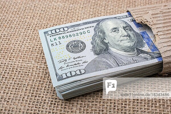 Banknotenbündel des US-Dollars  teilweise in Karton eingewickelt