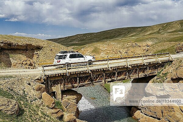 Auto mit Allradantrieb beim Überqueren einer Holzbrücke über eine wilde Schlucht  Provinz Naryn  Kirgisistan