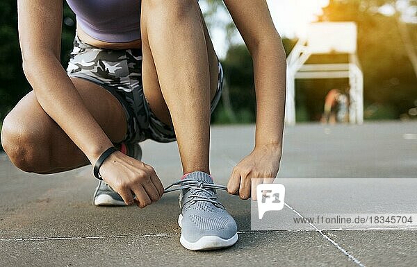 Sport Mädchen binden ihre Schnürsenkel in einem Park. Läuferin beim Binden ihrer Laufschuhe in einem Park mit Platz für Text  Nahaufnahme einer sportlichen Frau beim Binden ihrer Schuhe mit Kopierraum  Managua  Nicaragua  Mittelamerika