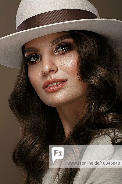 Schöne sexy Frau in einem modischen Hut  mit klassischem Make-up  Wellenhaar und Lächeln. Schönes Gesicht. Foto im Studio aufgenommen