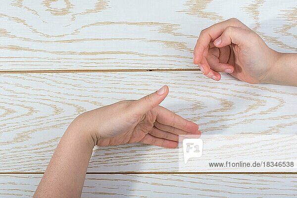 Hands making a gesture on a wooden background