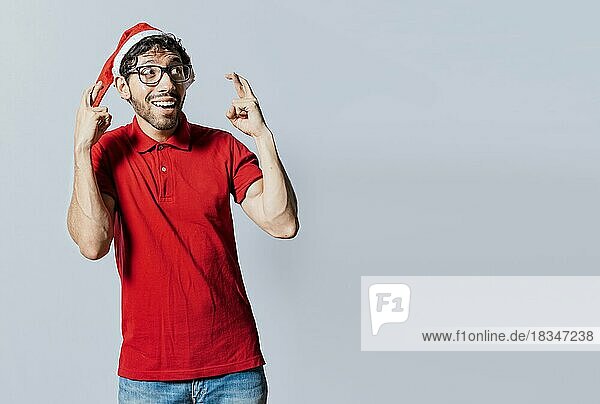 Mann mit Weihnachtsmütze wünscht sich etwas auf isoliertem Hintergrund  Hoffnungsvoller Mann in Weihnachtskleidung wünscht sich etwas  Schöner Mann mit Weihnachtsmütze wünscht sich etwas auf isoliertem Hintergrund