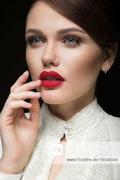 Schönes Mädchen mit roten Lippen in weißer Kleidung in der Form von Retro. Schönheit Gesicht. Bild im Studio aufgenommen