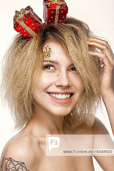 Fröhliches  schönes Mädchen in einem Neujahrsbild mit einem festlichen Make-up mit einem Lächeln. Die Schönheit des Gesichts. Fotos im Studio geschossen